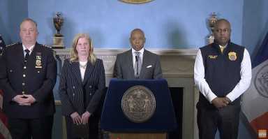 four people at a podium in NYC during press conference about immigration protests